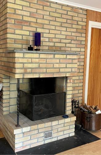a brick fireplace with a tv on top of it at Brekkesten by Norgesbooking - cabin in Stavern in Stavern