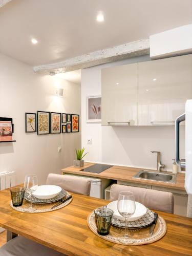 une cuisine et une salle à manger avec une table en bois dans l'établissement Logement entier Le Spa des Voutes Jacuzzi Cinéma, à Saint-Maximin-la-Sainte-Baume