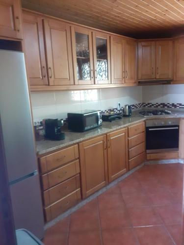 a kitchen with wooden cabinets and a stove top oven at Os Girassóis da Carla in Braga