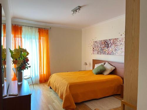 1 dormitorio con cama de color naranja y ventana en Vilamoura TOP MouraPraia, en Vilamoura