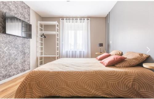 une chambre avec un lit avec des oreillers roses dessus dans l'établissement Appartement Modulable, à Arras