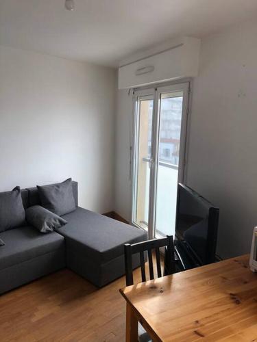 un salon avec un canapé et une table dans l'établissement Studio meublé à louer 100 m de métro ligne 7, à Villejuif