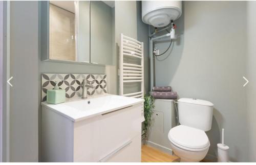 une salle de bain avec des toilettes blanches et un lavabo dans l'établissement Appartement Modulable, à Arras