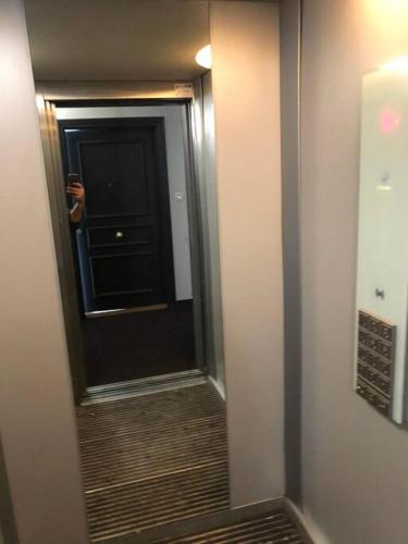 - un couloir avec une porte et un miroir dans la chambre dans l'établissement Studio meublé à louer 100 m de métro ligne 7, à Villejuif