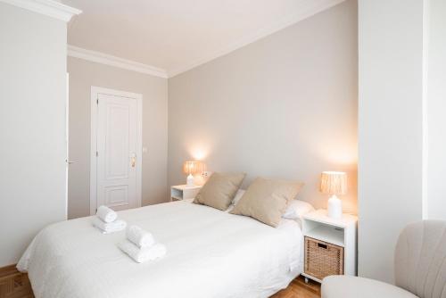 a bedroom with a white bed and two lamps at EnjoyGranada RECOGIDAS HOMES in Granada