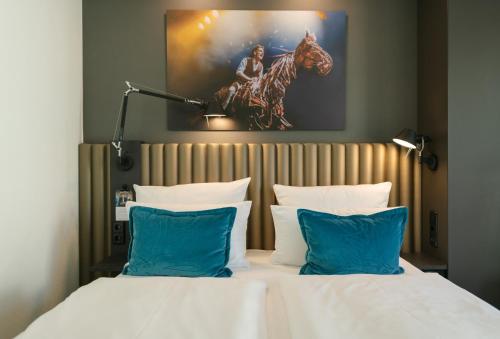 a hotel room with two beds with blue pillows at Motel One Berlin Ku'Damm in Berlin