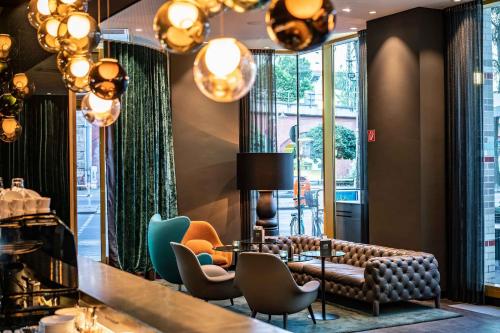 a lobby with a couch and chairs and windows at Motel One Berlin Ku'Damm in Berlin
