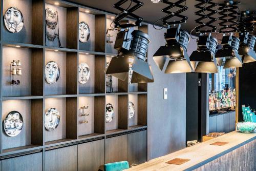 a restaurant with masks on the wall and lights at Motel One Berlin Ku'Damm in Berlin