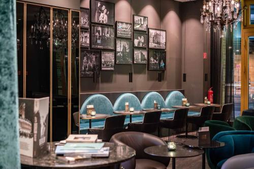 a restaurant with tables and chairs and pictures on the wall at Motel One Berlin Ku'Damm in Berlin