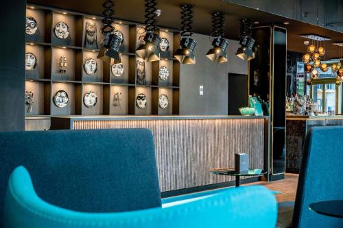 a restaurant with a blue bench in front of a counter at Motel One Berlin Ku'Damm in Berlin
