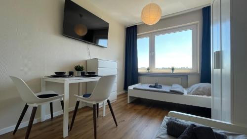 リューデンシャイトにあるGroße Wohnung mit 7 Betten, große Küche, Balkonのテーブル、椅子、ベッドが備わる小さな客室です。