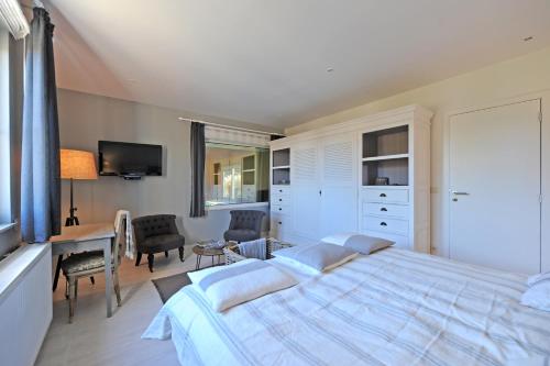 a bedroom with a large bed and a desk at La Couette de l'Ours in Aywaille