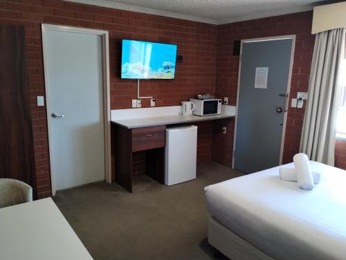 a hotel room with a sink and a microwave at Junction Motel Wagga in Wagga Wagga