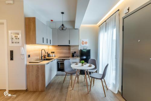 a kitchen and dining room with a table and chairs at Athena & Phevos Luxury Suite With View In Nea Makri in Nea Makri