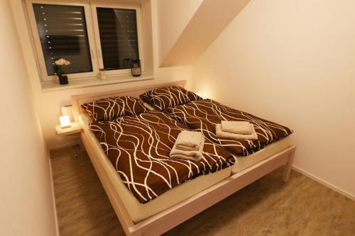 a bed with two towels on it in a bedroom at Penzion J&P Slavičín in Zlín