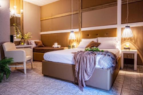 a bedroom with a large bed and a chair at Lino Mare Boutique Hotel in Amoudara Herakliou