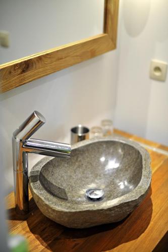 a bathroom sink with a granite counter top at La Couette de l'Ours in Aywaille