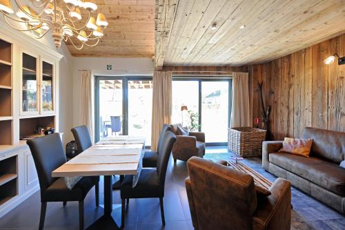 a dining room with a table and chairs and a couch at La Couette de l'Ours in Aywaille