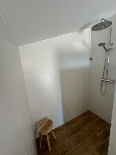 a small bathroom with a shower and a wooden stool at Casa Rural CAL PAGÉS Montseny in Montseny