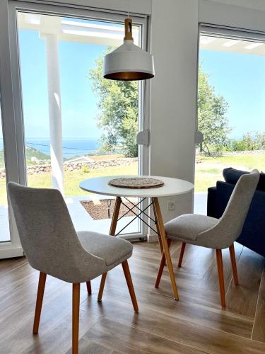 a table and chairs in a living room with a view of the ocean at Bungalow for 2 - Dream Oasis Dobra Voda in Dobra Voda