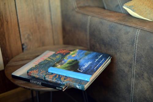 two books sitting on a table on a couch at La Couette de l'Ours in Aywaille