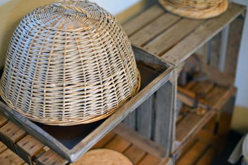 a wicker basket sitting on top of a wooden shelf at La Couette de l'Ours in Aywaille