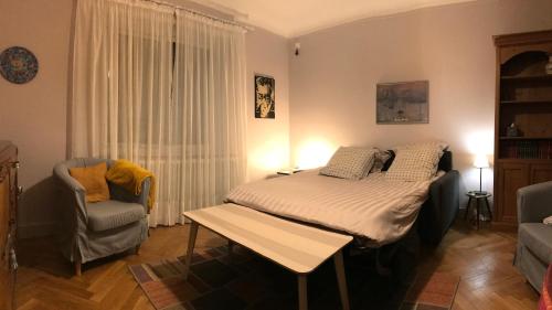 a bedroom with a bed and a chair at Le Passage Meublé de tourisme Trois Etoiles 1 à 6 voyageurs in Châtillon-sur-Chalaronne