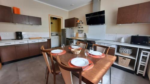 a kitchen with a wooden table and chairs in a kitchen at Le Passage Meublé de tourisme Trois Etoiles 1 à 6 voyageurs in Châtillon-sur-Chalaronne