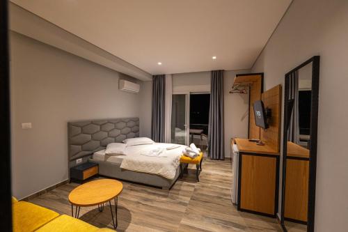 una camera d'albergo con un letto e una televisione di Sunkised Hotel a Sarandë