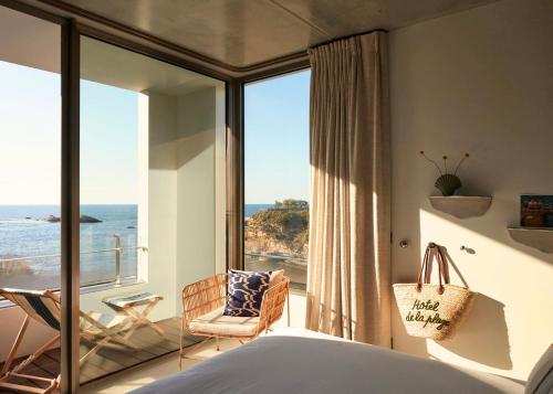 a bedroom with a bed and a view of the ocean at Hôtel de La Plage in Biarritz