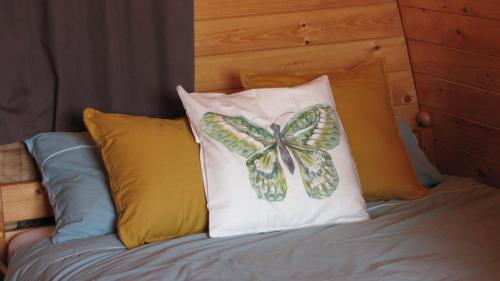 a butterfly pillow sitting on top of a bed at Swifterlodge in Kerkenveld