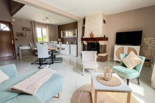 un salon avec un canapé bleu et des chaises dans l'établissement La maison d'Anne, à Saint-Arnoult