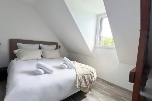 une chambre avec un lit blanc avec des serviettes dessus dans l'établissement La maison d'Anne, à Saint-Arnoult
