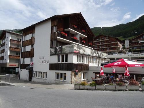 a building with an umbrella in front of it at Hotel Gebidem in Visperterminen