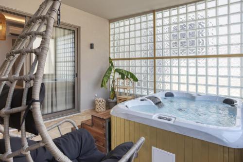 a jacuzzi tub in a room with a large window at Royal Gold City Suites by Omilos Hotels in Heraklio Town