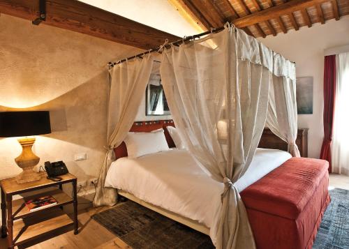 a bedroom with a canopy bed and a red couch at La Barchessa di Villa Pisani in Lonigo