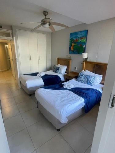 Una habitación con tres camas y un ventilador de techo. en B5 Salamander, en Durban