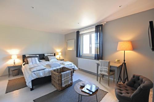 a bedroom with a bed and two chairs at La Couette de l'Ours in Aywaille