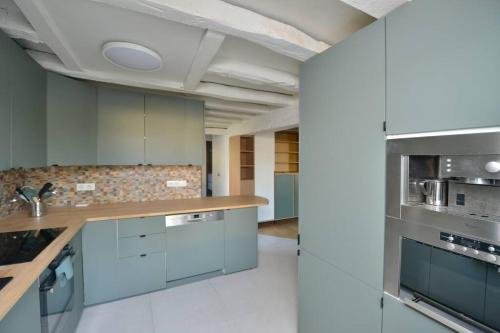 une cuisine avec des armoires blanches et un comptoir dans l'établissement Maison entièrement rénové de 4 pièces, à Nogent-le-Roi