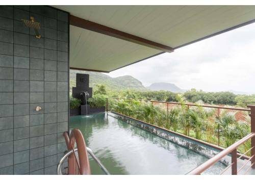 a swimming pool on a balcony with a mountain view at Malhar Machi Mountain Resorts in Mulshi