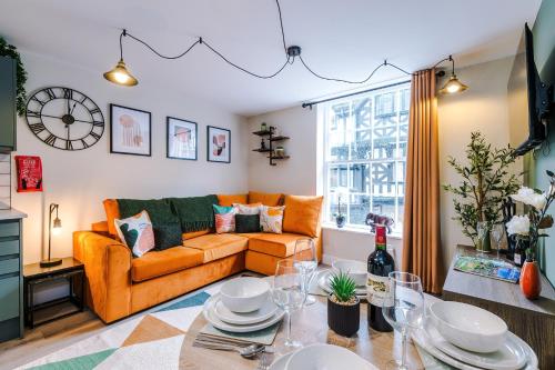 a living room with an orange couch and a table at NEW! 4 x Stunning City Centre Apartments in Chester by 53 Degrees Property, Ideal for Individuals, Couples or Business Groups! in Chester