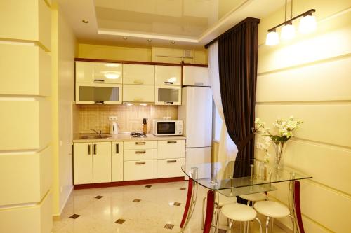 a small kitchen with a glass table and stools at Ultra Central Park Apartments in Chişinău