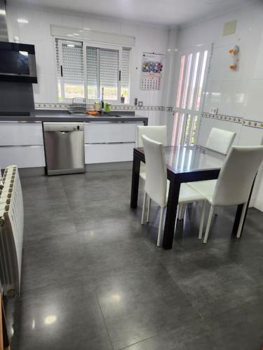 a kitchen with a dining table and white chairs at Casa Villa Molins in Valencia
