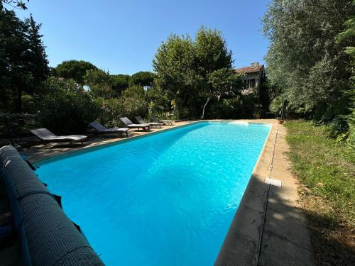 une grande piscine avec de l'eau bleue dans une cour dans l'établissement Le repaire magique, à Roquebrune-sur Argens