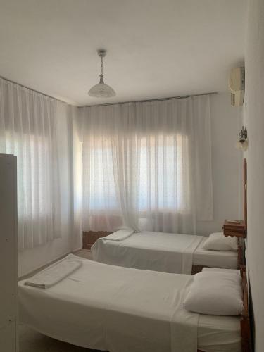a hotel room with three beds and a window at Kristal pansiyon in Dalyan