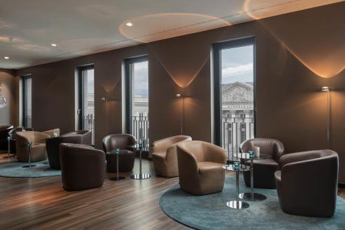 a waiting room with chairs and tables and windows at Motel One Berlin-Potsdamer Platz in Berlin