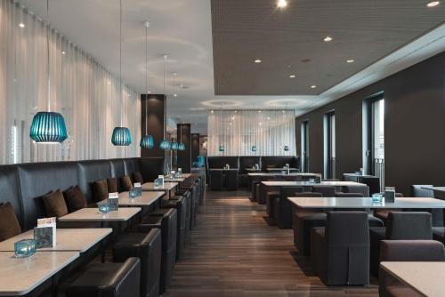 a dining room with tables and chairs and tablesktop at Motel One Berlin-Potsdamer Platz in Berlin