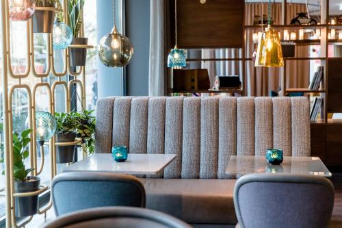 a couch in a room with chairs and tables at Motel One Essen in Essen