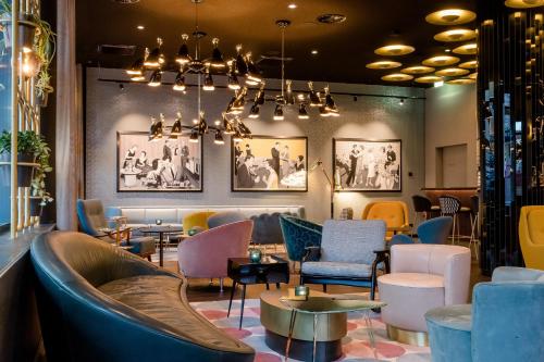 a lobby of a restaurant with chairs and tables at Motel One Essen in Essen