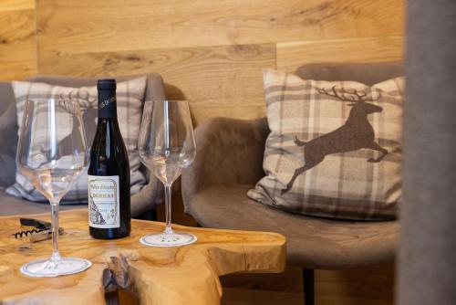 a bottle of wine and two glasses on a table at Hotel Relais Des Glaciers - Adults Only in Champoluc